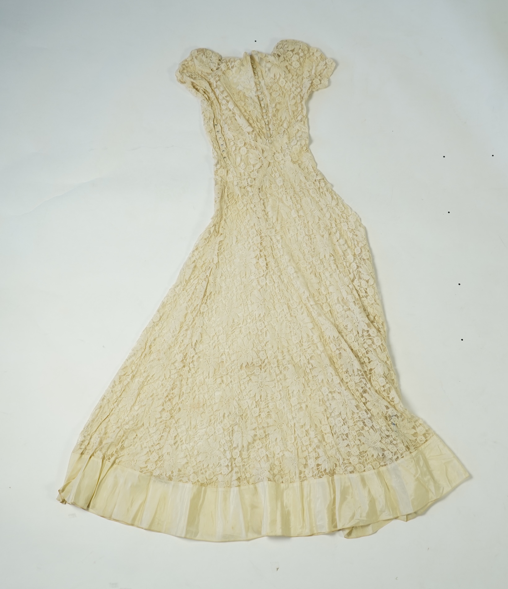 An early 1940's cream cotton lace and taffeta evening dress, with matching taffeta petticoat, possibly worn as a wedding dress., Dress 144cm long. Condition - minor repairs needed to lace in places and laundering to remo